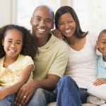 Family sitting in living room smiling